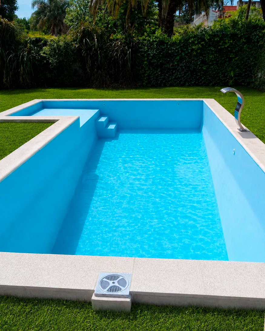 Piscina de material con cascada de acero inoxidable construida en Rosario por RA Construcciones.